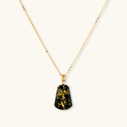 18k gold-plated necklace and earrings with green amber pendants featuring golden inclusions on cream background